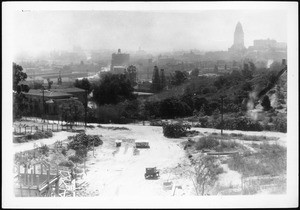 View of the dirt lanes of the North Figueroa Street construction site, showing wooden structures and an automobile, February 1936