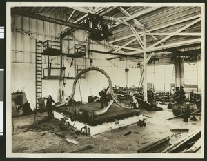 Workers showing a method of pipe bending at the Crane Company, ca.1920