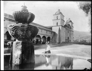 Mission Santa Barbara, showing Moorish fountain and woman in foreground, 1908