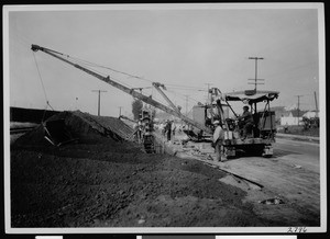 Steam shovel moving dirt near a road in Los Angeles