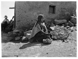 Hopi Indian woman mixing corn flower for Piki (bread) in the village of Mishongnovi, ca.1901