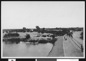 People crowded at a portion of the levee which held back the Colorado River at the "Lower Heading," near Yuma