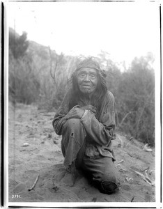 Old Havasupai Indian man crouching on the ground, ca.1900