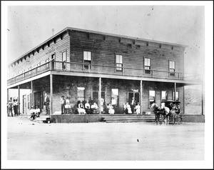 Guests on the porch of a hotel in Johannesburg (Randburg?), showing a horse-drawn cart, ca.1898