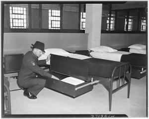 Man checking the beds at the Terminal Island Federal Prison