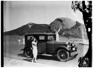 Two women and an automobile near the Eagle Rock in Los Angeles
