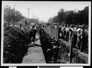 Crowd of workers constructing a storm drain