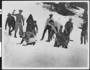 Several people engaging in a footrace and snowball fight in the snow, ca.1930