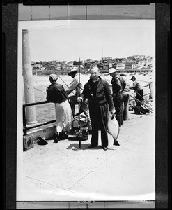 Portrait of a man with a flounder on the Manhattan Beach pier, May 27, 1937