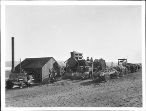 Mule team and loaded ore wagons at stamp mill, Mojave Desert, ca.1900