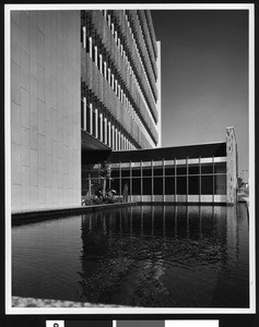 Exterior view of the new Los Angeles Hall of Records building on the corner of Broadway and Temple Street , shown from reflecting pool, ca.1960