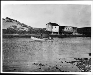 Fishermen in a rowboat in Playa Del Rey, with their homes in the background, ca.1902