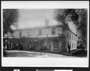 Group of about fifteen people on the porch of the Ojai Valley Inn, ca.1880