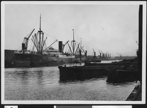 Single steamship at a wharf, showing several boats in the water, ca.1920