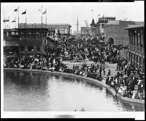 Crowd of onlookers huddled around the edge of Central Lagoon on Windward Avenue, Venice, ca.1915