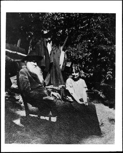 Portrait of Joaquin Miller and his daughter seated outdoors