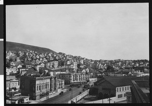 Birdseye view of buildings on the side of a hill and street-cars in San Francisco, 1930