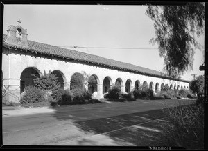 Exterior view of the San Fernando Mission, showing tall grass in the foreground