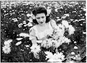 Woman sitting in a field of Marconi daisies