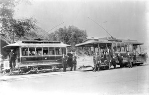 Portrait of people posed around two electric streetcars at Sycamore Park, ca.1895