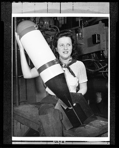 Portrait of a woman holding an aircraft bomb, 1930-1940