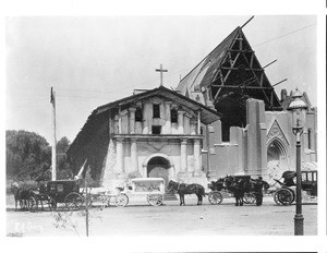 Exterior view of the Mission Francis de Asis (Dolores) after the earthquake, showing a funeral procession in front, San Francisco, ca.1906