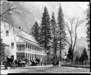 Exterior view of the Sentinel Hotel in Yosemite, with wagons in front, 1895-1905