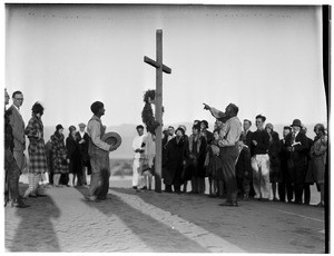 People gathered around a cross at a funeral