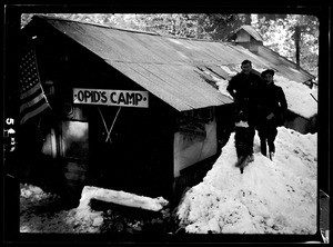 Two people standing outside a cabin at Opid's Camp