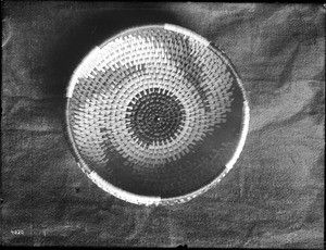 Indian basket displayed against a cloth backdrop, ca.1900