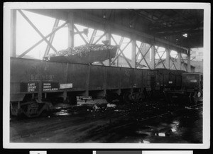 Department of Public Works truck bed raised over an open railroad car for emptying