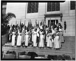 Women holding flags on the steps of City Hall during the dedication of Simon Bolivar Plaza, Pan American Day