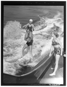 A man and a woman water skiing