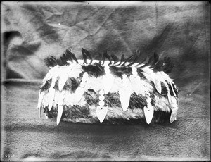 Indian basket displayed in front of a cloth backdrop, ca.1900