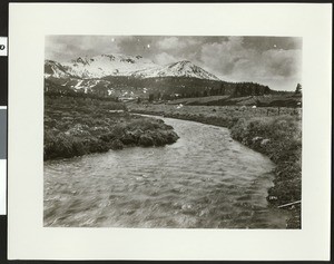 Unidentified tumultuous river curving toward snow-capped mountains, ca.1950