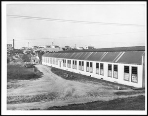Exterior view of the Golden State Textiles Weaving Plant, showing residences in the background, 1910-1940