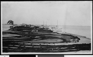 San Pedro, showing a man repairing a net along the docks