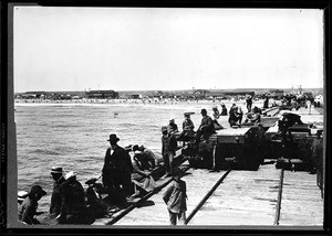 People seated on a railroad pier in Newport Beach, ca.1908