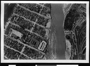 Aerial view of unidentified flooded area, showing city blocks at left and container at right, 1938