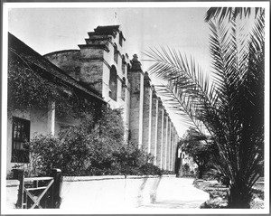 Exterior view of Mission San Gabriel from the sidewalk near the belfry, San Gabriel, ca.1900
