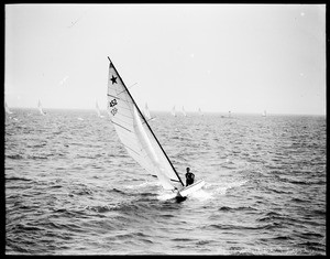 Sailboat with its sails tipped towards the left on the ocean, Long Beach