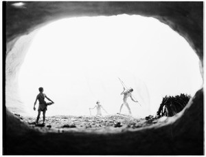 Display of three early humans in a cave, depicted at the Natural History Museum