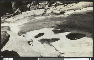 Yosemite Creek above the falls, showing holes worn into the granite by stones, ca.1930-1940