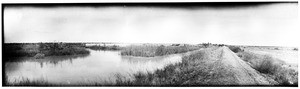 Panoramic view of wagons moving past an irrigation ditch in the Imperial Valley