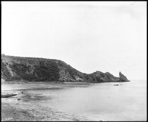 View of rocks and a small boat on the south end of Newport Beach (Balboa), ca.1906-1908