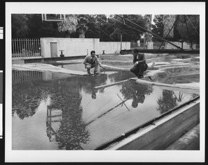 Two men standing on top of a large model of waterways, ca.1925