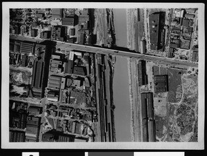 Aerial view of a flooded area, showing a highway over the river, 1938