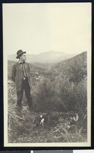 Man standing next to a pine sapling