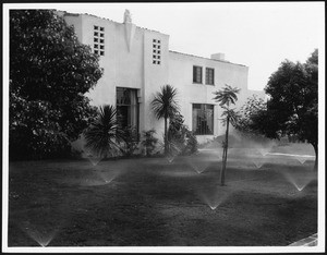 Sprinklers in front of an unidentified home, ca.1935