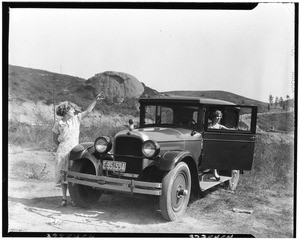 Two women posing with an automobile near the Eagle Rock in Los Angeles